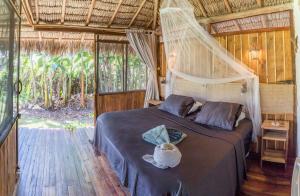 a bedroom with a bed with a net at Vila do Junco in Santo Amaro