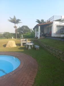 a house with a pool and a picnic table next to it at Seaview Unit 3 in Port Shepstone