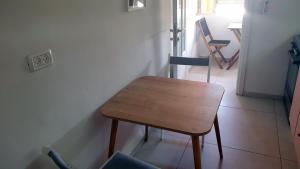 Gil's Home of Joy & Serenity في حيفا: طاولة وكراسي خشبية صغيرة في الغرفة