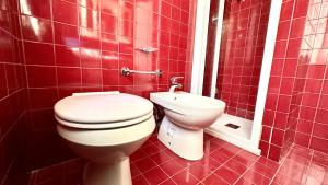a red tiled bathroom with a toilet and a sink at Bilocale con portico a Numana - N175 in Numana