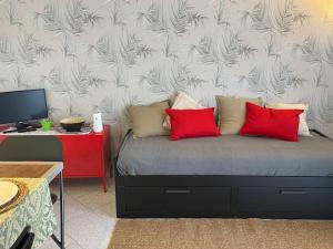 a bedroom with a bed with red pillows on it at La Casetta 115 fronte lago in Castelletto sopra Ticino