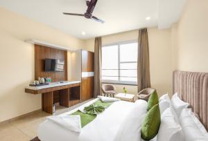 a hotel room with a bed and a tv at One Earth Elegant in Rishīkesh
