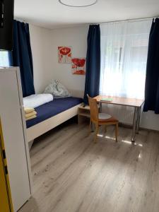 una camera da letto con un letto, una scrivania e un tavolo di Kleine drei Länderzentrale a Hohenems