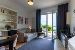 ein Wohnzimmer mit einem Sofa und einer Glasschiebetür in der Unterkunft Casamina vista lago Verbania in Arizzano