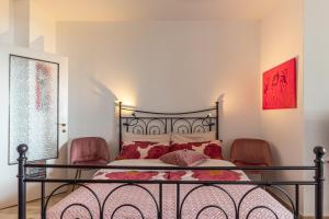 1 dormitorio con 1 cama con 2 sillas rojas en Casamina vista lago Verbania en Arizzano