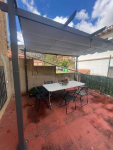 a table and chairs under a white canopy on a patio at Apartamento JUMIDOSIV in Aliaga