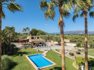 an aerial view of a villa with a swimming pool and palm trees at Villa Can Cosme in Alcudia