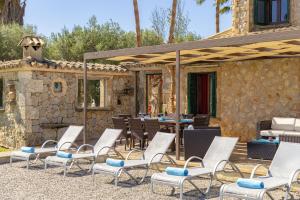 eine Gruppe von Stühlen und Tischen auf einer Terrasse in der Unterkunft Villa Can Cosme in Alcúdia