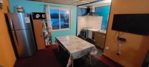 uma pequena cozinha com uma mesa e um frigorífico em Pies a tierra em Coihaique