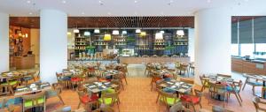 a restaurant with tables and chairs and a bar at Hilton Garden Inn Kuala Lumpur - South in Kuala Lumpur