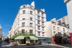 un edificio blanco alto en una calle de la ciudad en Hotel Apolonia Paris Mouffetard, Sure Hotel Collection by Best Western en París