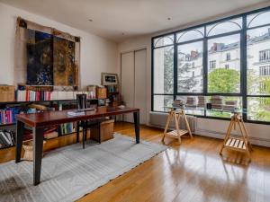 ein Büro mit einem Schreibtisch in einem Zimmer mit Fenstern in der Unterkunft Paris Mozart Prestige Residence in Paris