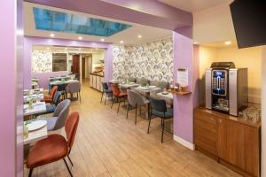 um restaurante com mesas e cadeiras e paredes roxas em Hotel Apolonia Paris Mouffetard, Sure Hotel Collection by Best Western em Paris