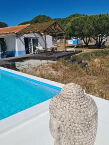 un vaso di pietra appoggiato accanto a una piscina di Modern Farmhouse AYO South of Melides a Giz