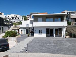 a white house with a parking lot in front of it at Apartments Paradise Hvar in Hvar