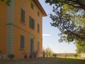 um edifício laranja com persianas verdes em Lovely holiday home in Montefiridolfi with hill view em Montefiridolfi