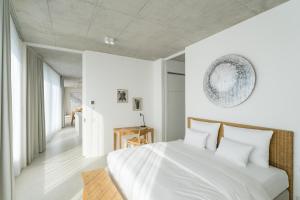 a bedroom with a white bed with white pillows at Wilmina Apartments & Lofts in Berlin