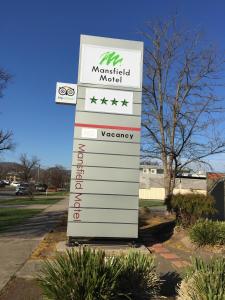 a sign for a medicalanical motel in a parking lot at Mansfield Motel in Mansfield