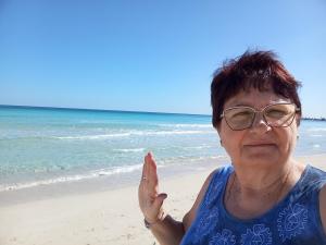 a woman in glasses standing on the beach at Agriturismo Il Pavone in Torre Lapillo +95 photos