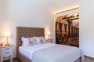サンタ・マルタ・デ・ペナギアンにあるQuinta da Pousada Casa de Campoのベッドルーム1室(白い大型ベッド1台、ナイトスタンド2台付)