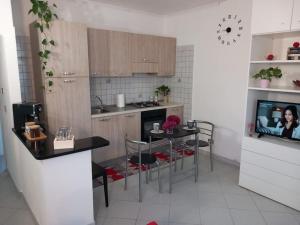 a kitchen with a table and a tv in it at casa Andreea in Domodossola