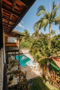 een uitzicht over een zwembad en palmbomen bij Residencial Canto da Praia - Jureia in Juréia