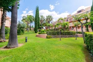 a park with palm trees and a building at ALTAVISTA ISLANTILLA GOLF by MSHOLIDAYS in Islantilla