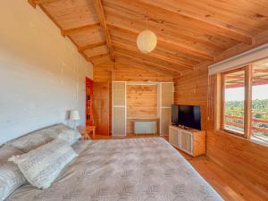 Schlafzimmer mit einem Bett und einem Flachbild-TV in der Unterkunft Yatehue Lodge in Chadmo