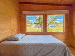 Schlafzimmer mit einem Bett vor einem Fenster in der Unterkunft Yatehue Lodge in Chadmo