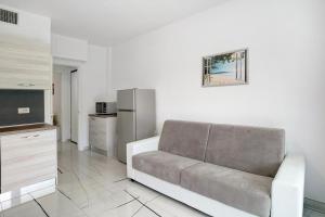 a living room with a couch and a refrigerator at Le Vigne Marina di Andora in Marina dʼAndora