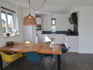 a kitchen with a wooden table and chairs at 55 Bytling in Terherne