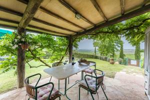 a table and chairs on a patio with a view at Casa vacanze Aurora in Isola d'Arbia