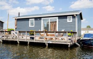 a tiny house on a dock on the water at Pet Friendly Home In Breukelen With Kitchen in Breukelen