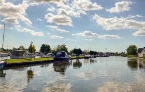 een boot is aangemeerd in een rivier met wolken in de lucht bij Awesome Home In Breukelen in Breukelen