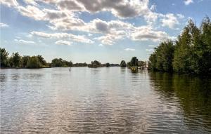 een uitzicht op een rivier met bomen en een bewolkte lucht bij Awesome Home In Breukelen in Breukelen +9 foto's