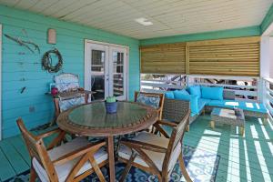 a dining room with a table and chairs on a porch at Pelican Bend by Pristine Properties Vacation Rentals in Indian Pass