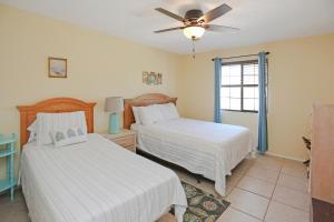 - une chambre avec 2 lits et un ventilateur de plafond dans l'établissement Pelican Bend by Pristine Properties Vacation Rentals, à Indian Pass