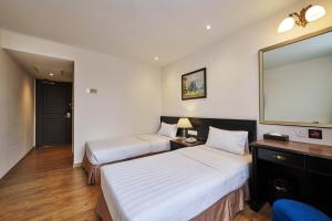 Postel nebo postele na pokoji v ubytování PJ De Inn Hotel