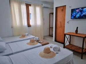 2 Betten mit Hüten auf einem Zimmer in der Unterkunft Casa Mar Self Jeri in Jericoacoara