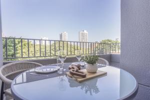 a white table on a balcony with wine glasses at 360 My Moema in São Paulo