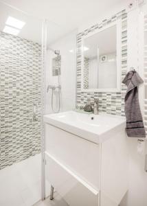 biała łazienka z umywalką i prysznicem w obiekcie Margaret Studio near the Danube w Budapeszcie