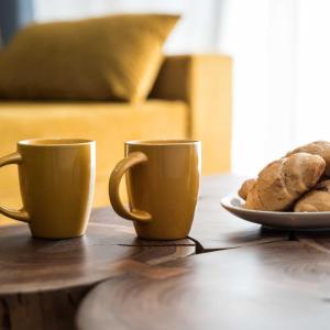 zwei Kaffeetassen und einen Teller Brot auf dem Tisch in der Unterkunft Classy Apartment in Athens in Athen
