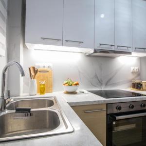 a kitchen with white cabinets and a sink at Classy Apartment in Athens in Athens