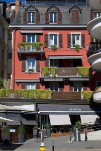 a large red building with plants on the balconies at La Rouvenaz in Montreux