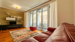 a living room with a couch and a large window at Modern Luxury Loft Porta Nuova - Parcheggio Privato in Turin
