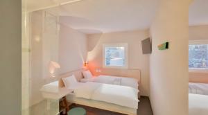 1 dormitorio con 1 cama y pared de cristal en Greet Hotel Nice Aéroport Promenade des Anglais en Niza