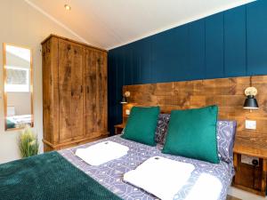um quarto com uma cama com almofadas verdes e brancas em Hazel em Swadlincote