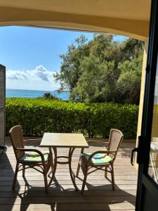 un tavolo e sedie su un patio con vista sull'oceano di Hotel Thalassa a Cargèse