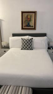 uma cama branca com uma almofada em cima em La Terrazza Vercelli Bed & Charme em Vercelli