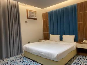 um quarto com uma cama grande e cortinas azuis em كيان ألين em Abha